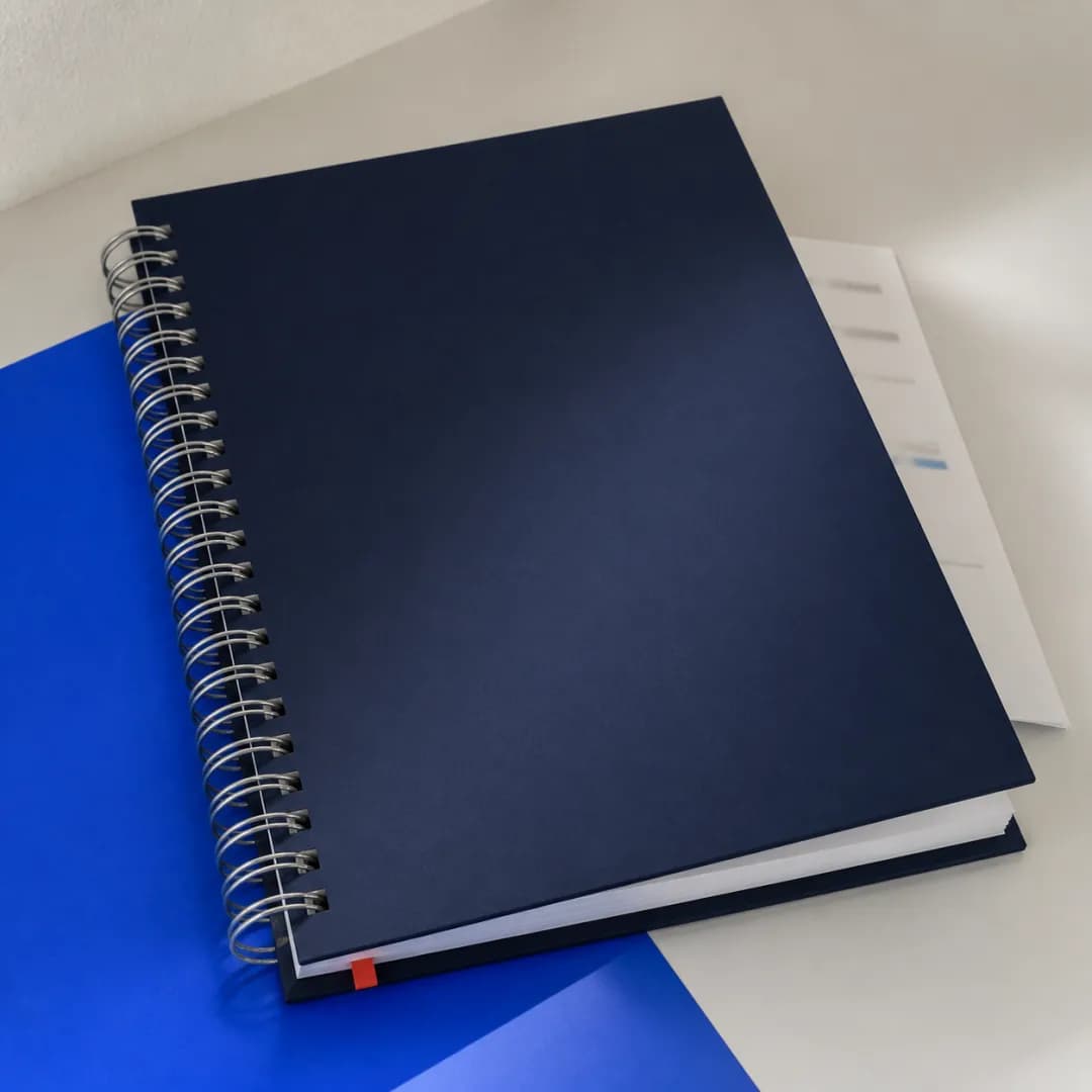 Manual de capa dura azul-marinho encadernado com wire-o metálico.